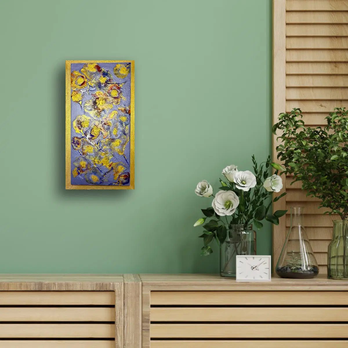 Framed abstract painting on a green wall with a wooden shelf and decorative items.