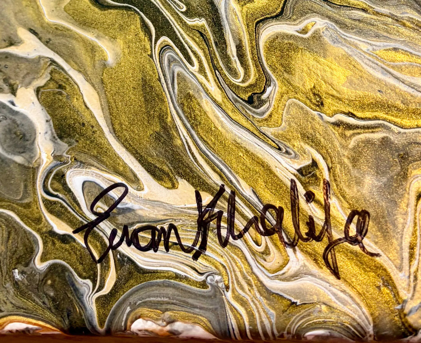 Marbled surface with a signature of eman khalifa in the center