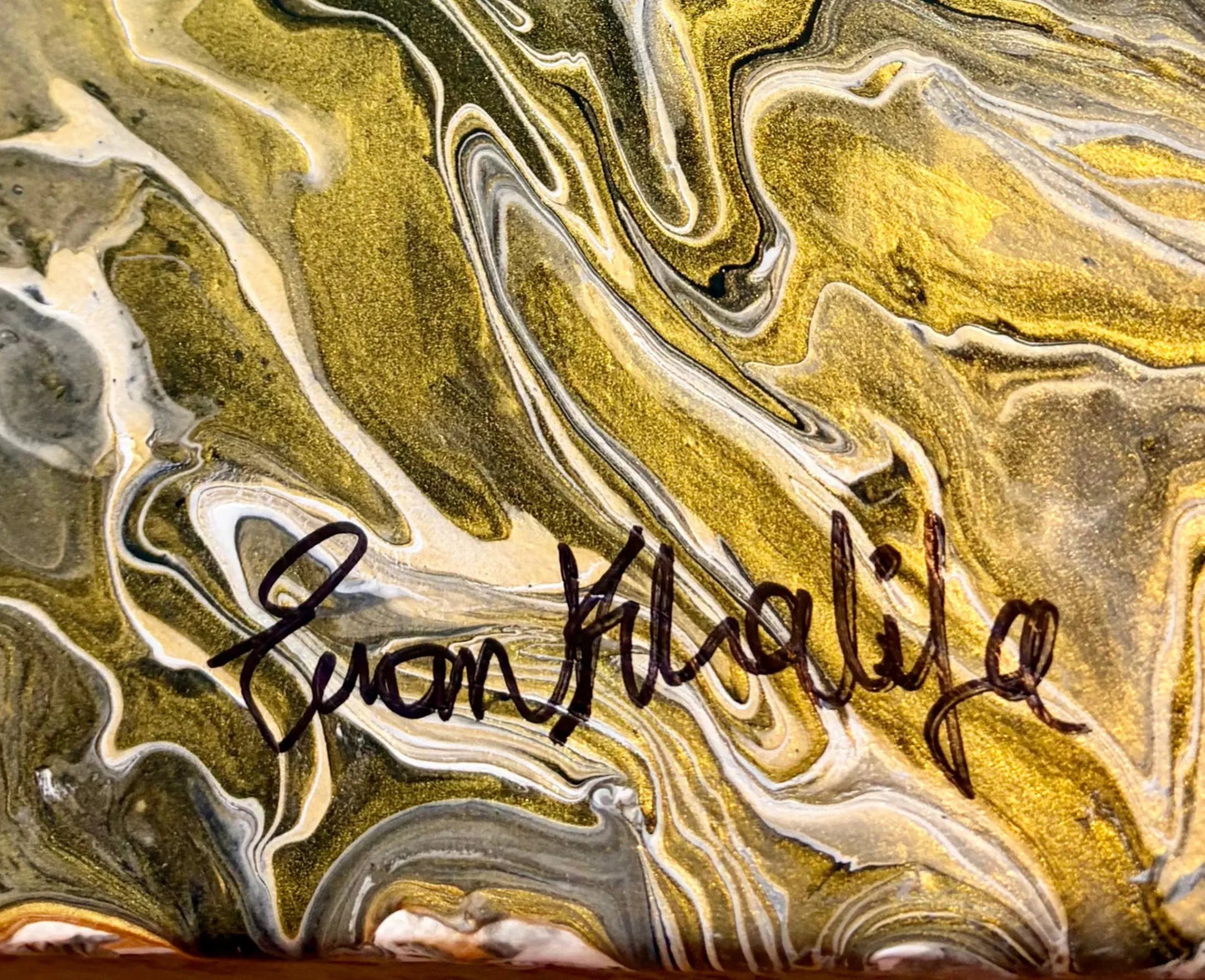 Marbled surface with a signature of eman khalifa in the center