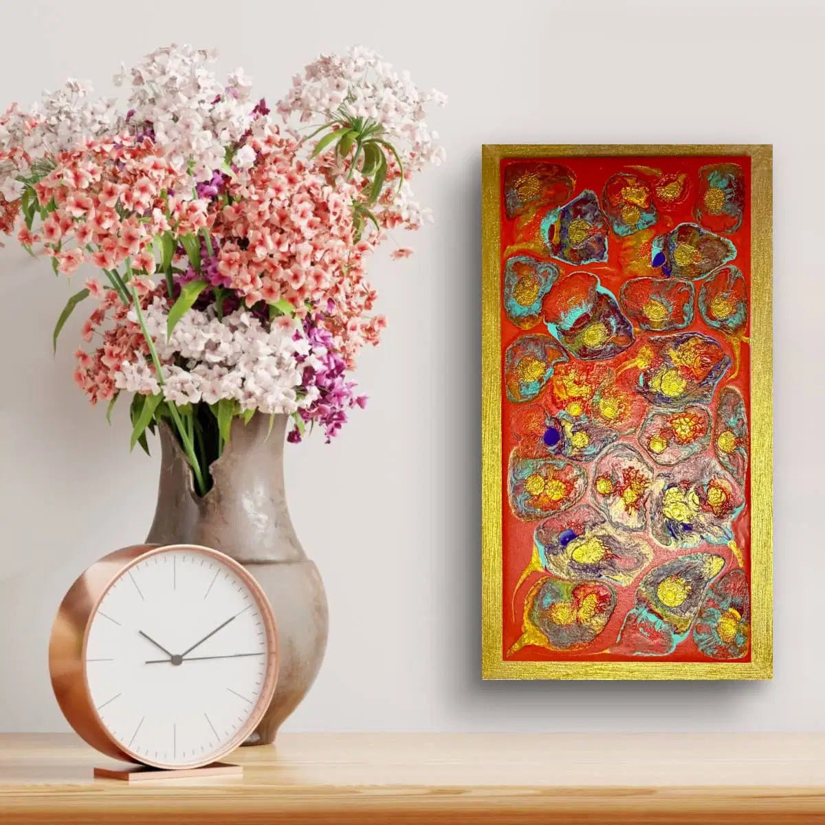 Decorative setup with a vase of flowers, clock, and colorful abstract painting on a wall.