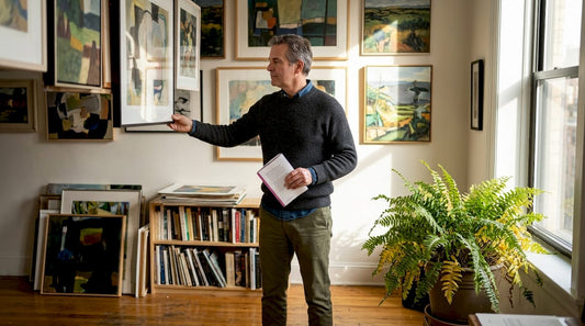 Art collector adjusting paintings in home