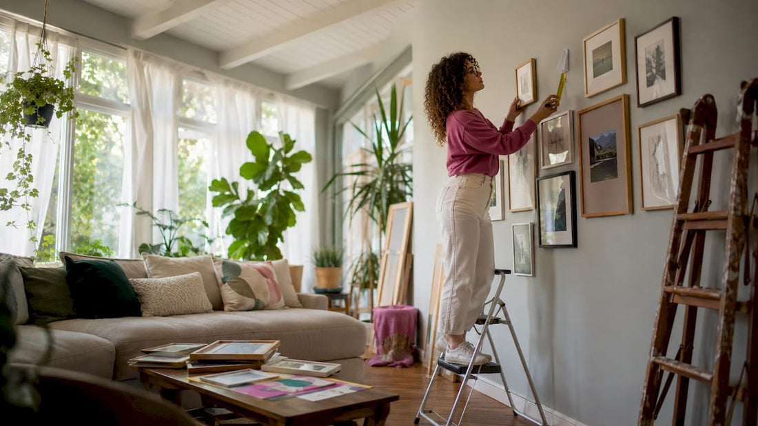 Person arranging art frames on wall