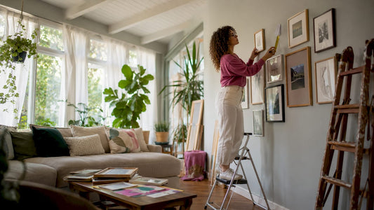 Person arranging art frames on wall