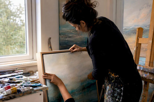 Artist mounting canvas in floating frame