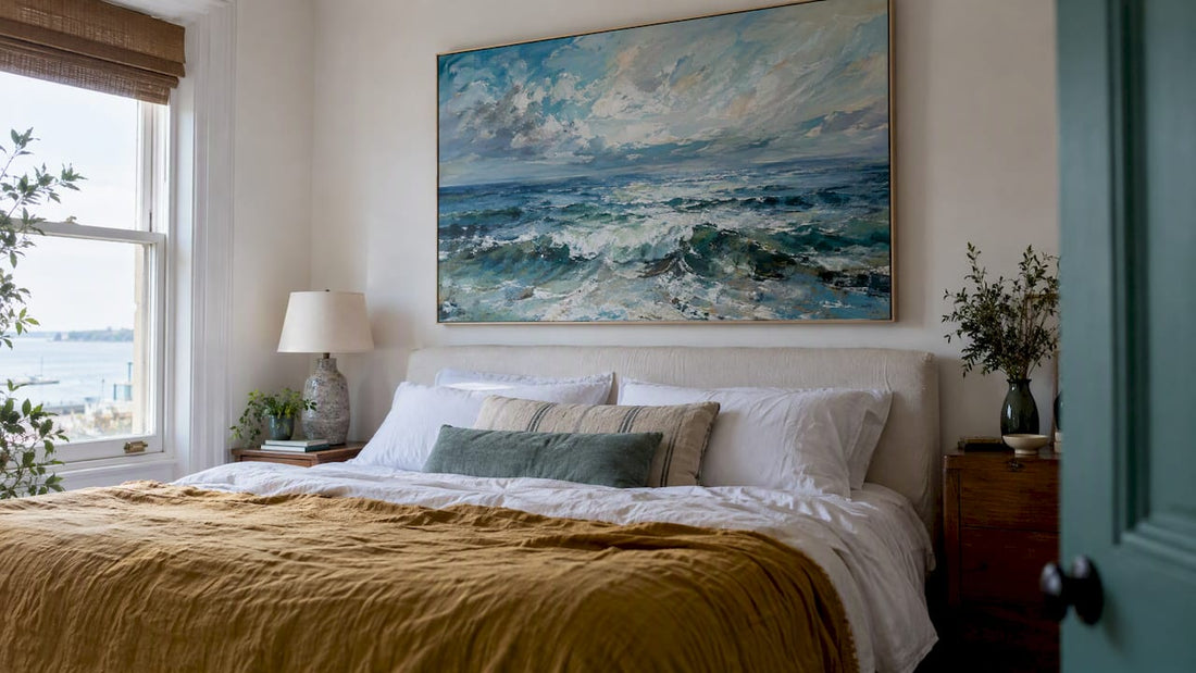 Seascape painting hung above a bedroom bed