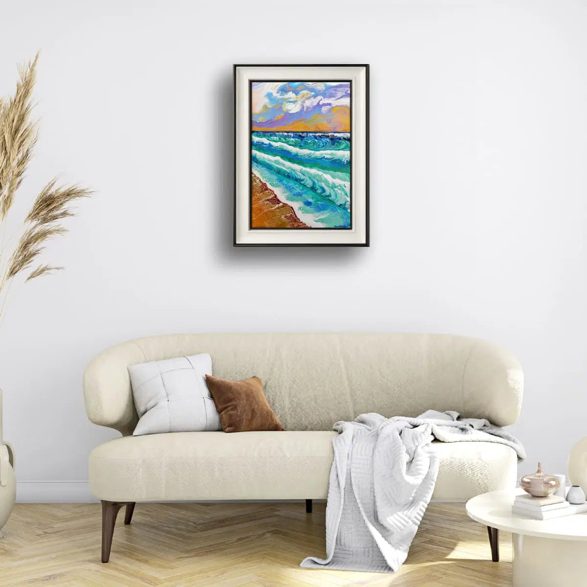 Framed artwork of a beach scene above a beige sofa in a living room.