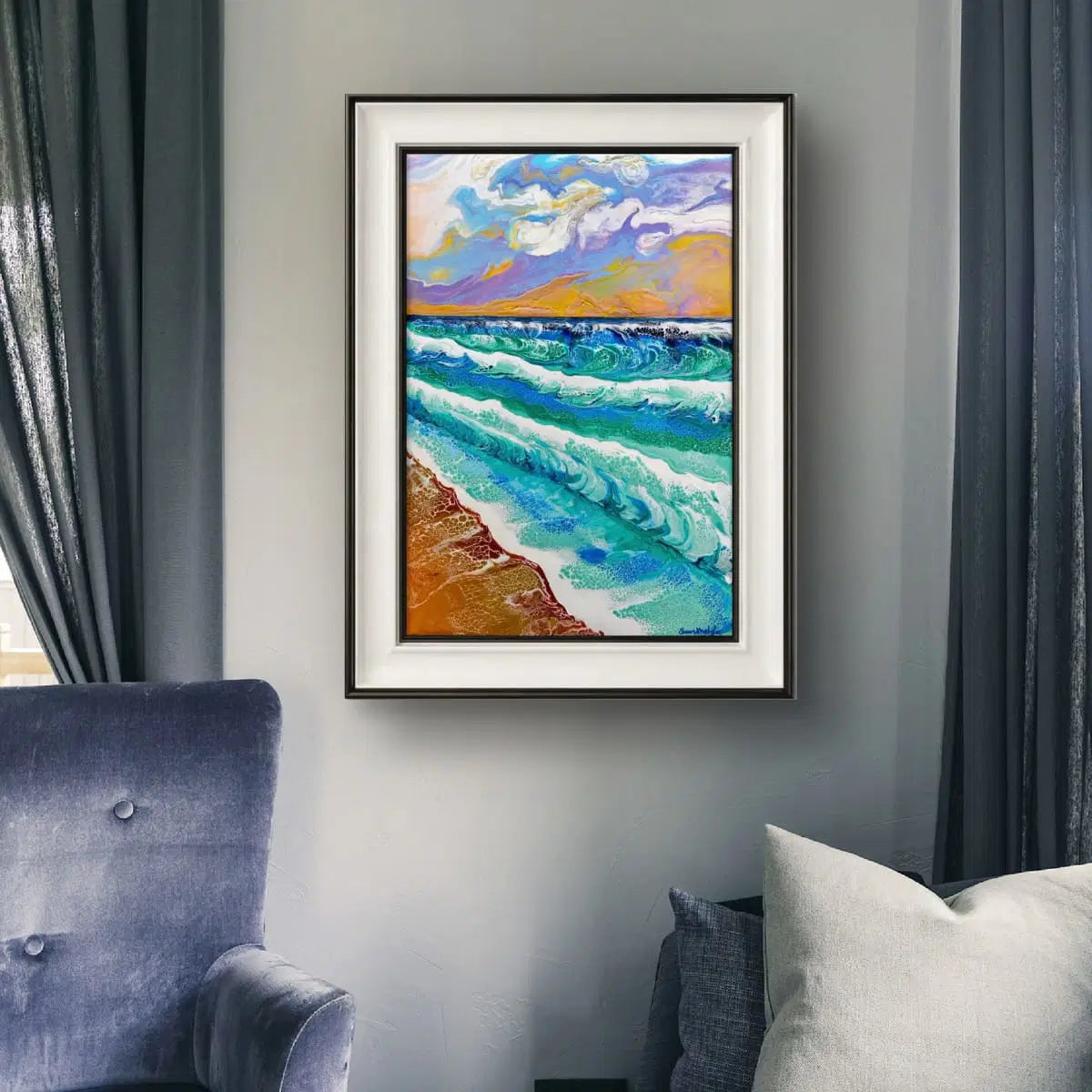 Framed painting of a beach scene on a wall above a chair.