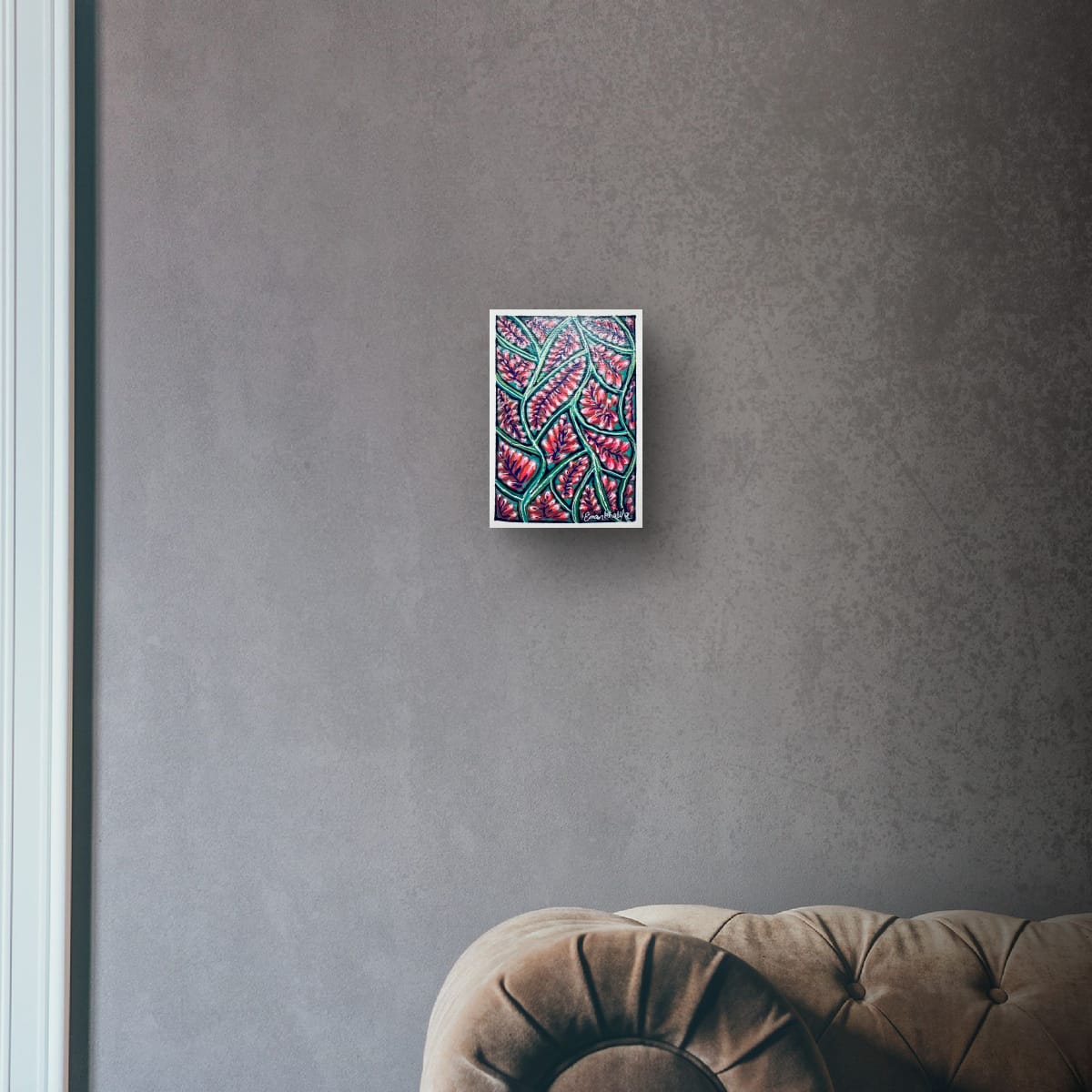 Framed abstract artwork of an A6 original acrylic painting featuring a vibrant floral bloom pattern with red blossoms and green botanical lines by Eman Khalifa, on a gray wall above a brown sofa