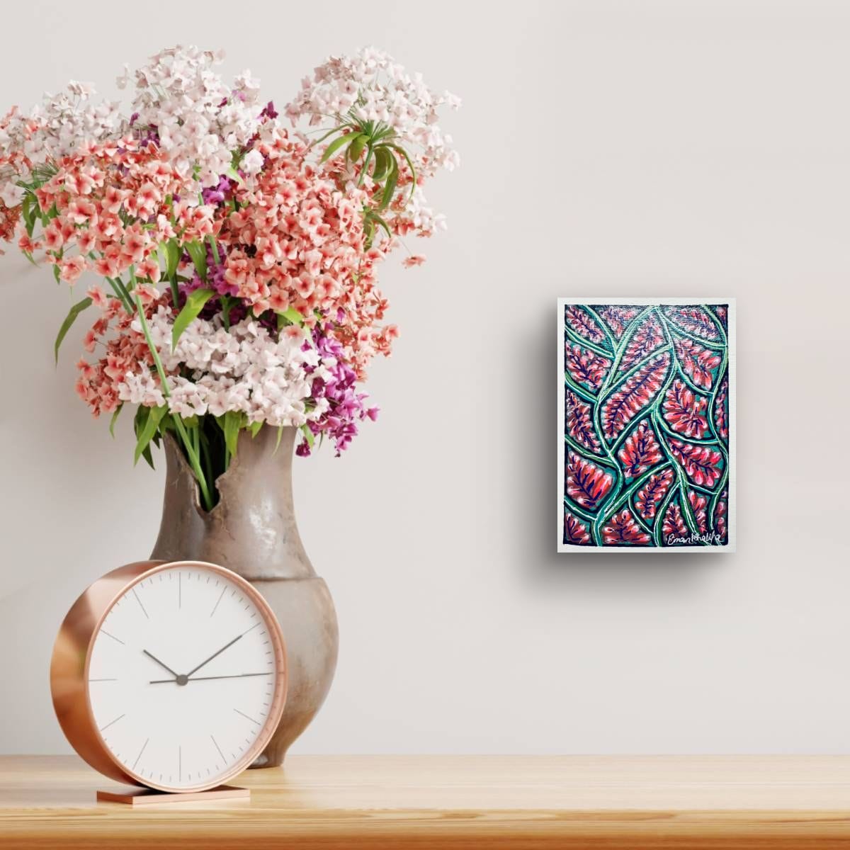 Decorative table setting with flowers, clock, and abstract A6 original acrylic painting featuring a vibrant floral bloom pattern with red blossoms and green botanical lines by Eman Khalifa.