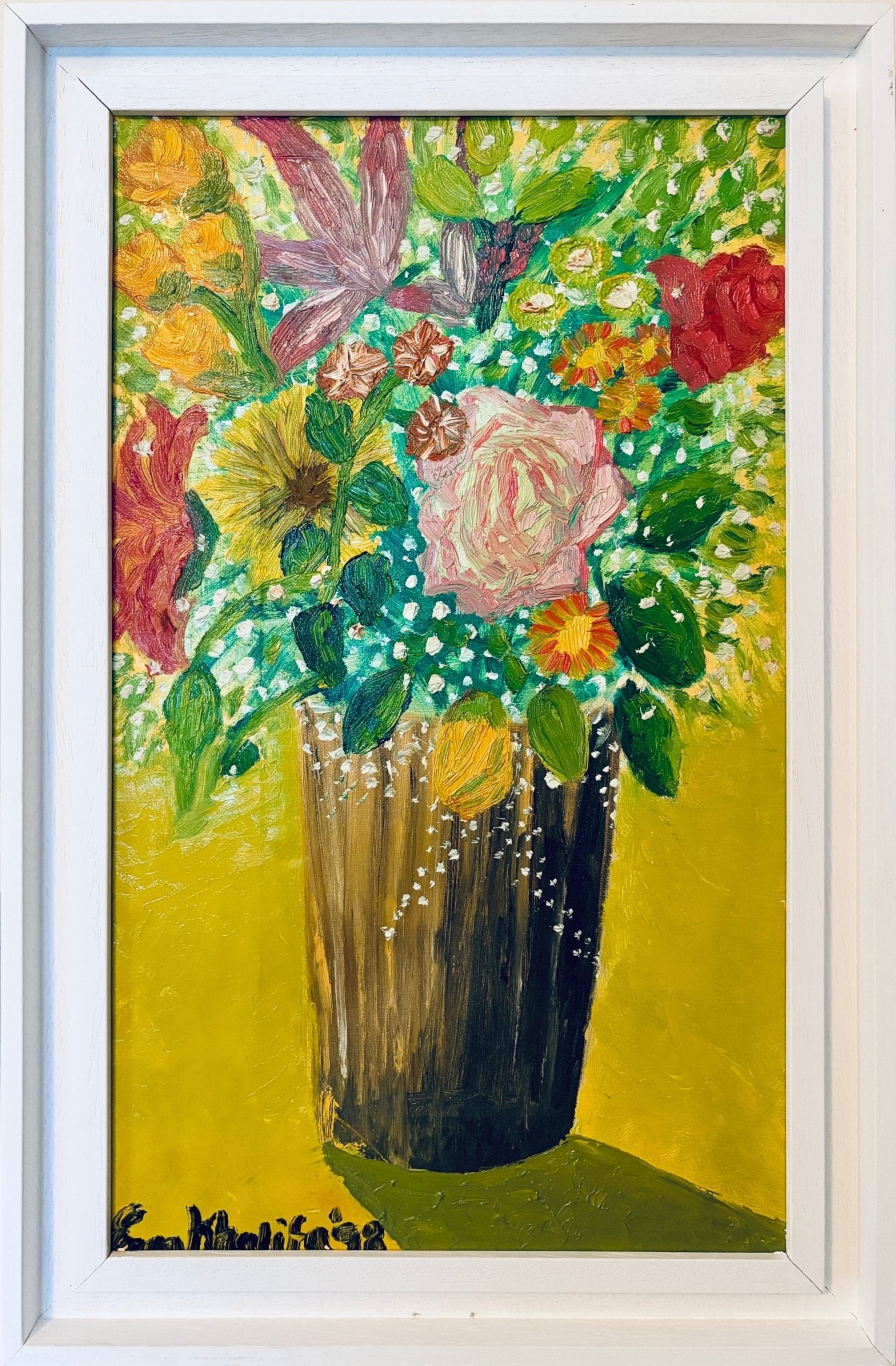 A framed painting of a vibrant floral bouquet in a dark brown vase against a bright yellow background, housed in a white frame.