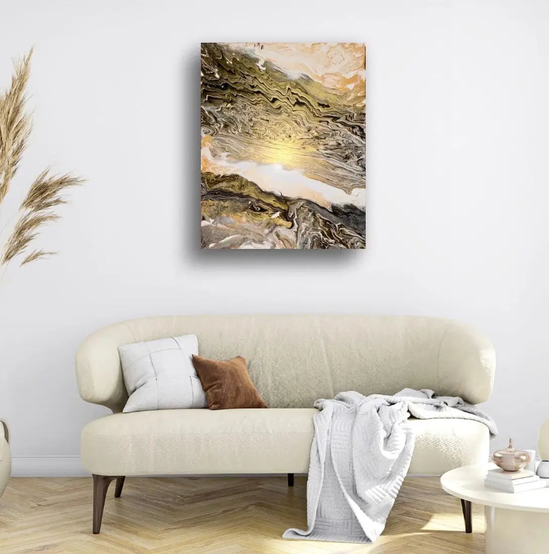 Beige sofa with decorative pillows and a blanket, featuring an abstract painting on the wall.