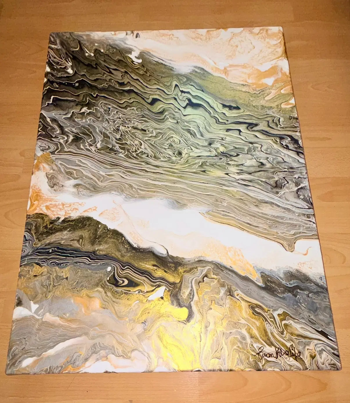 Abstract art piece with swirling colors on a wooden surface