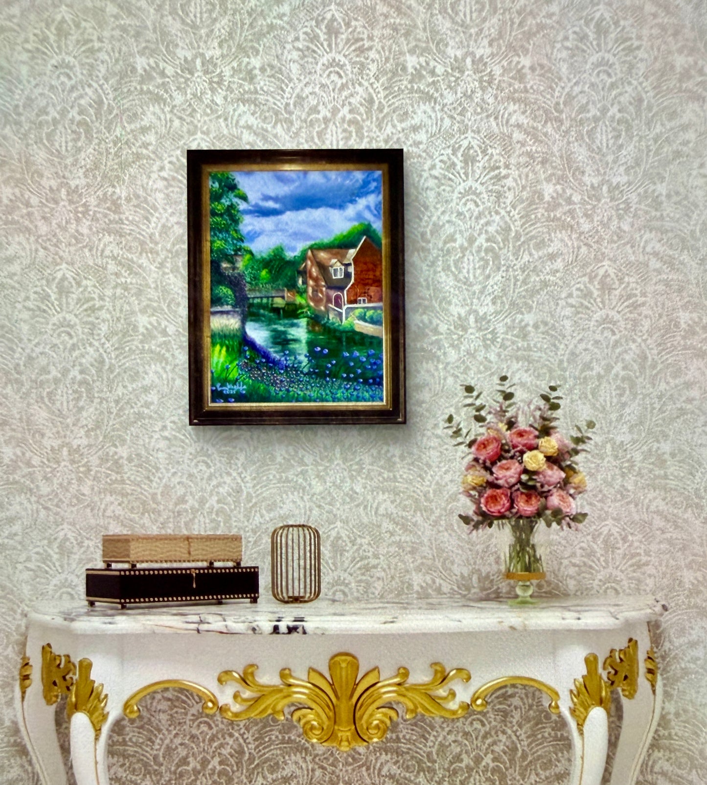 Framed painting on a wall above a decorative console table with a vase of flowers.