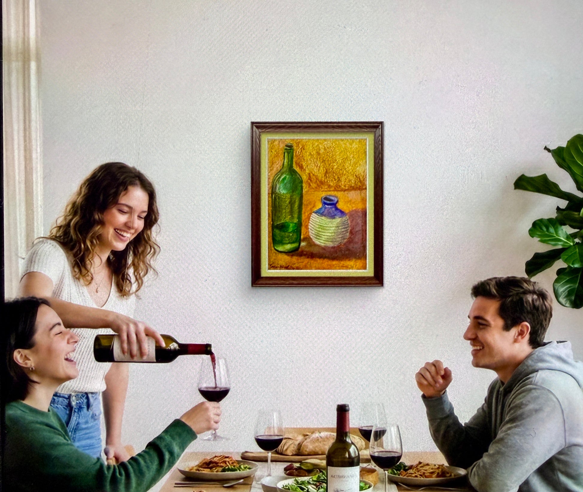 Two women and a man enjoying a meal together with wine, sitting at a table in a cozy room.
