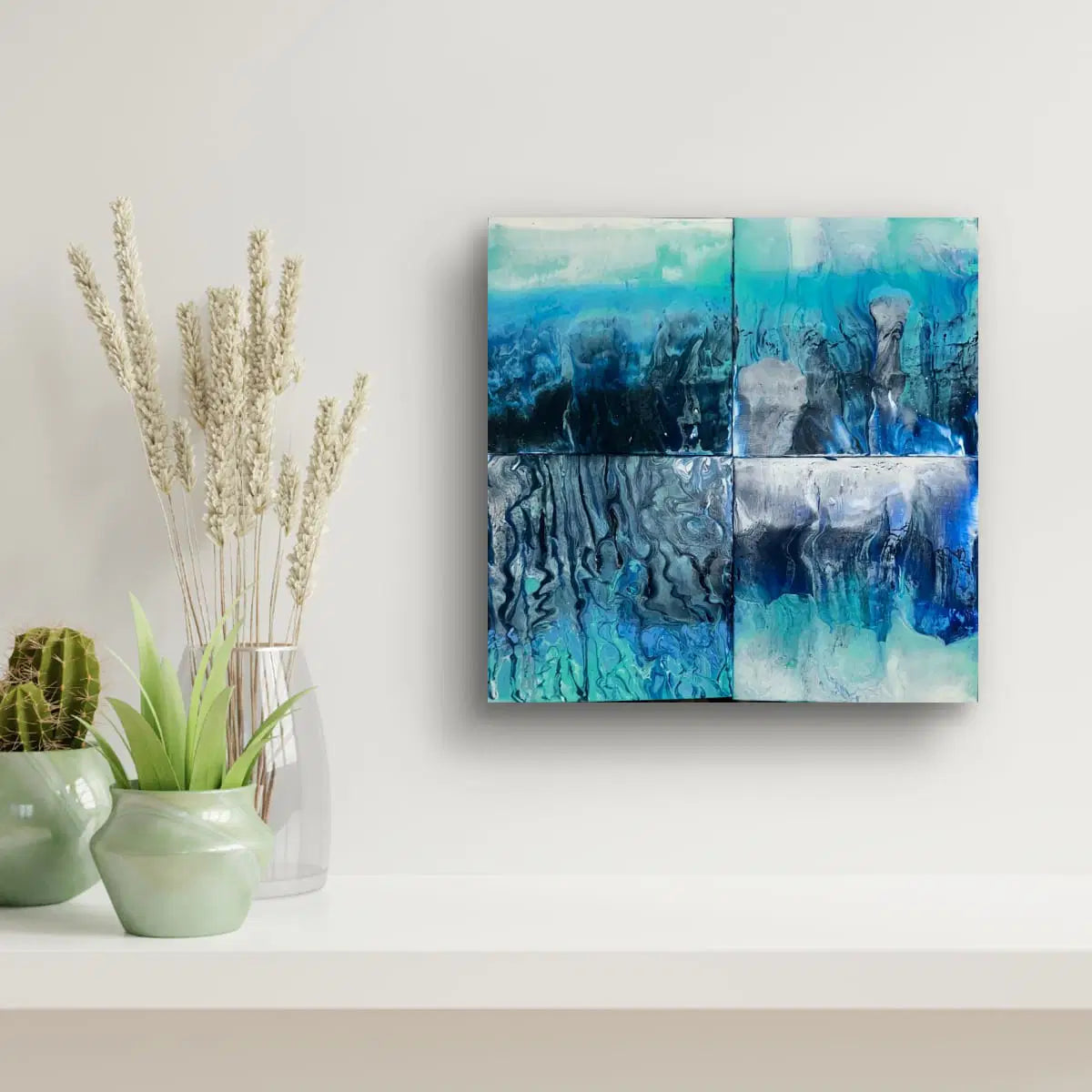 Abstract blue art piece on a wall with decorative plants below.