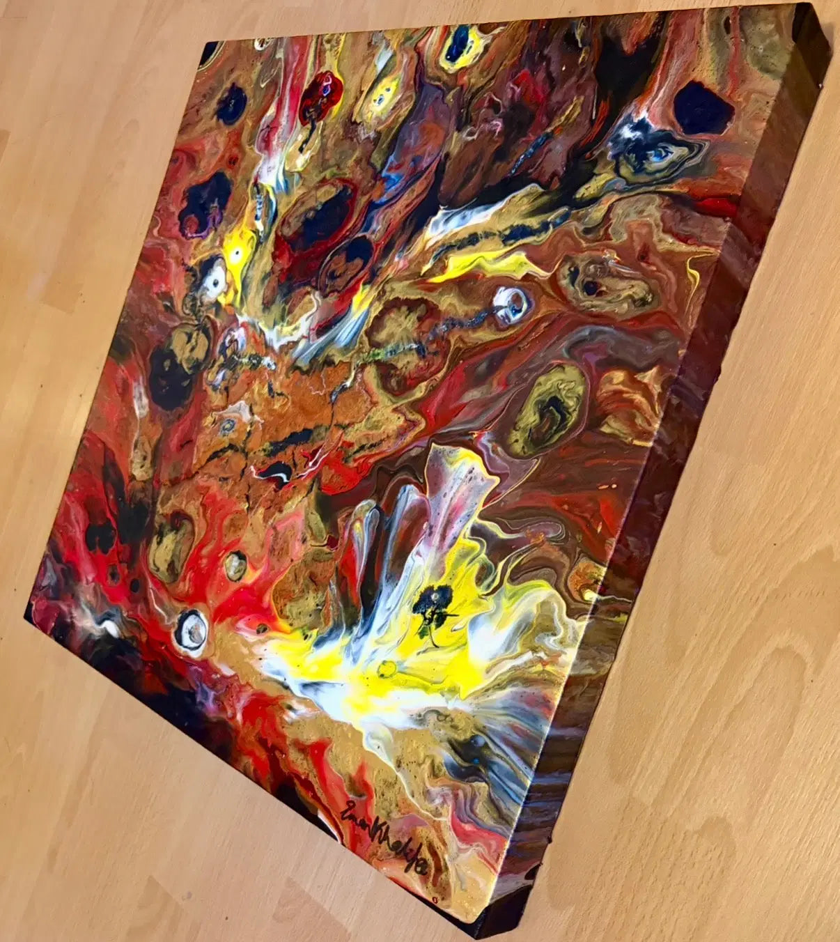 Abstract fire colours painting with swirling colors on a wooden surface